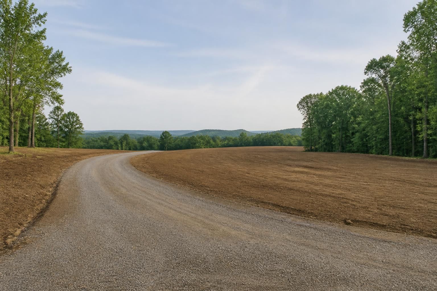 Completed rural lot with smooth driveway grading and open space.