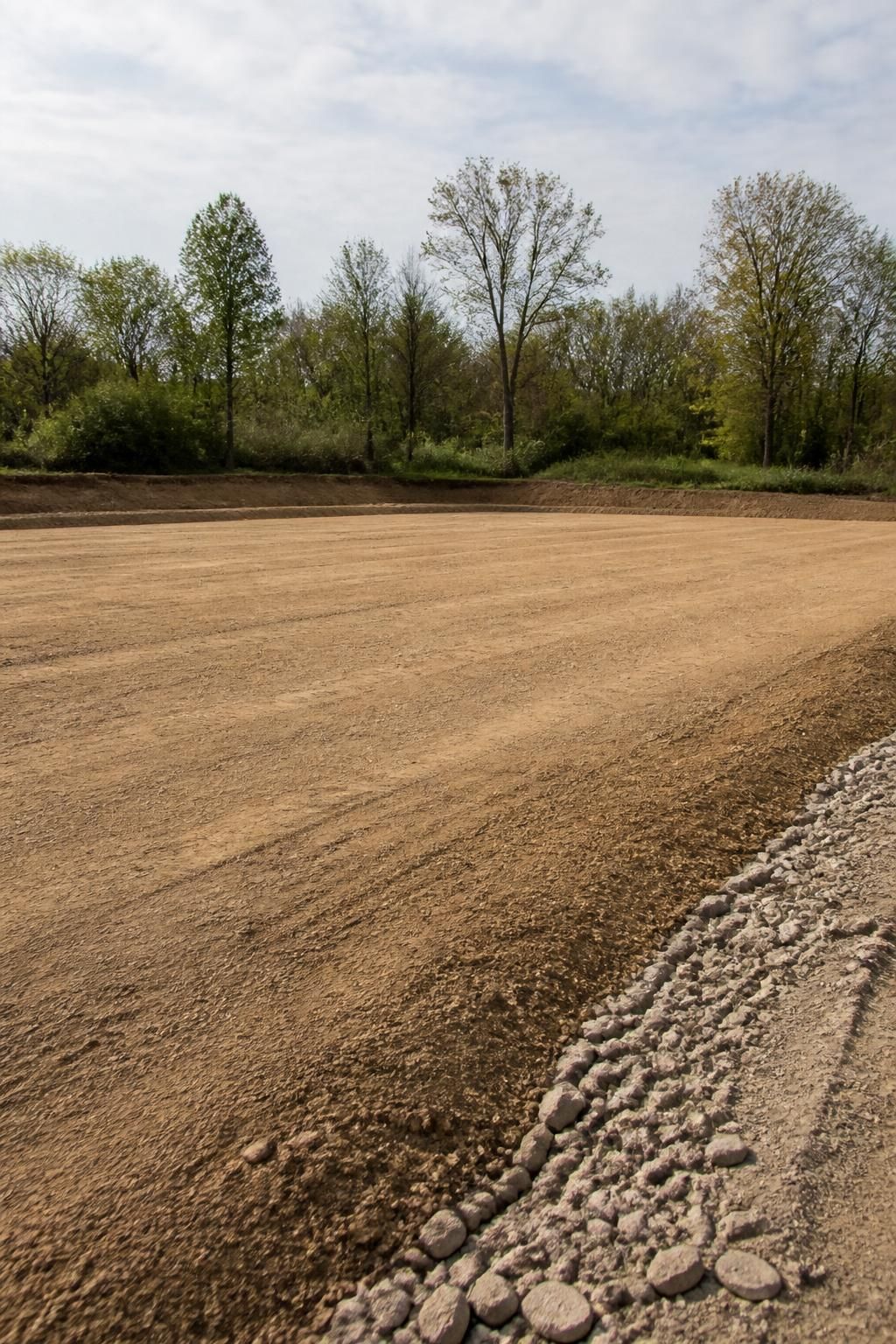 Leveled lot with clean edges and trees in the background.